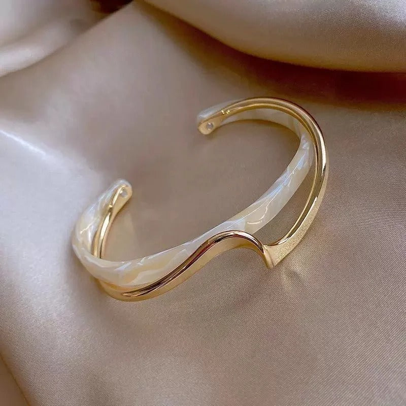 Clara – Pulsera geométrica abierta con silueta curva y un acabado moderno y elegante